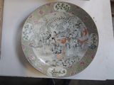 a plate with a painting on it sitting on a table