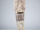 an old wooden sculpture of a head on a black stand