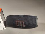 the jbl charge 3 portable speaker is next to the box