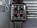 a close up of a black watch with a red second hand