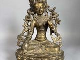 une statue en bronze représentant une femme assise en position du lotus