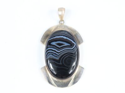 une photo d'un pendentif orné d'une pierre noire et bleue