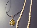 collier de perles avec un pendentif en pierre jaune monté sur un cordon noir