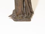 bronze statue of a woman holding a sword and a book