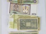 several different bank notes are laid out on a white surface