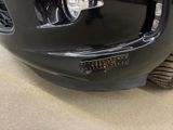 the front end of a black car with a chrome bumper