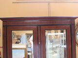 a large wooden cabinet with two mirrors on the wall