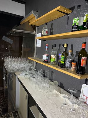 bottles and glasses are lined up on a counter in a bar