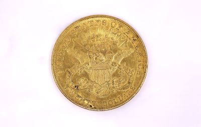 a close up of a gold coin on a white surface
