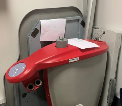 des toilettes avec un siège rouge et un distributeur de papier