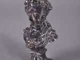 a close up of a silver statue of a woman on a pedestal