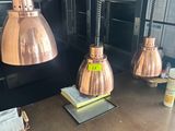 three copper lamps hanging from the ceiling of a kitchen