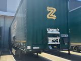 a green semi truck that is parked in front of a building