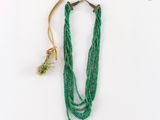 gros plan d'un collier de perles vertes sur fond blanc