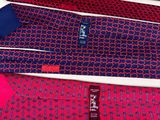 three ties with different designs on them sitting on a white surface