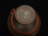 a brown vase with a frosted top on a black surface