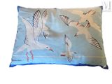 a pillow with a picture of seagulls flying in the sky