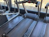 two tread machines in the gym with a view of the field