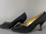 a pair of black high heeled shoes with a gold buckle