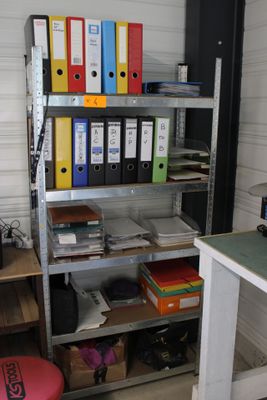 un bureau avec plusieurs dossiers et une chaise dans la pièce