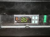 a digital clock on the side of a black oven