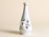 un vase blanc orné d'un crâne, posé sur une table
