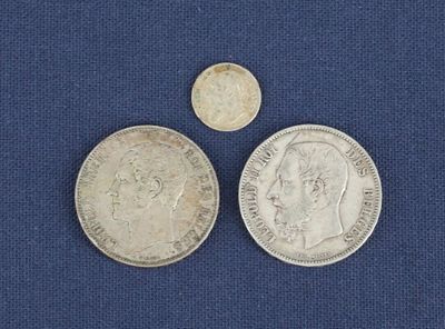 deux pièces d'argent et une pièce d'argent posées sur un tissu bleu