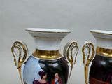 two vases with pictures on them sitting on a table