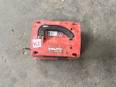 une boîte rouge munie d'une poignée noire, posée par terre