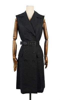 Le mannequin porte un manteau noir et une robe noire.