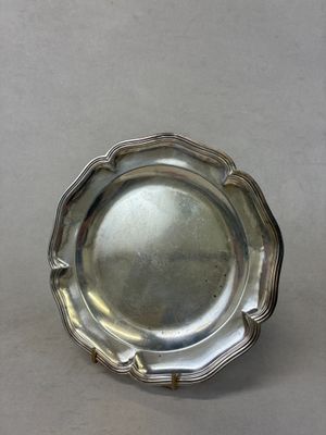 un plat en argent ancien posé sur une table, sur fond blanc
