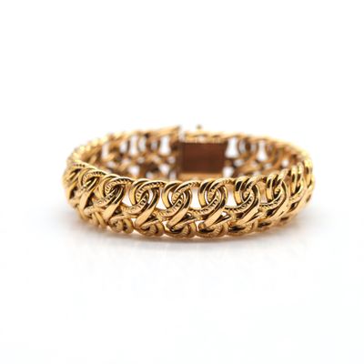 a close up of a gold bracelet on a white background