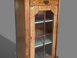 une vieille vitrine en bois avec des portes vitrées et des étagères