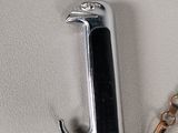 a silver and black pen with a chain on a white surface