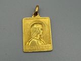 un gros plan d'un pendentif en or orné du portrait d'une femme