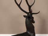 an image of a statue of a stag sitting on a wooden floor