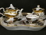 a tray with a tea set on it on a black background