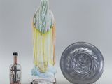 a statue of a woman holding a glass bottle next to a glass bottle