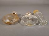 three glass perfume bottles sitting next to each other on a table