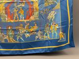 une image représentant une écharpe bleue et jaune ornée d'une scène de cirque
