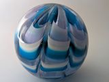 une boule en marbre bleu et blanc posée sur une surface blanche