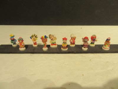 une rangée de figurines miniatures représentant différents personnages, disposées sur une étagère