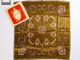 une photo d'un foulard carré sur lequel est posé un livre