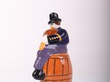 a figurine of a man sitting on top of a barrel