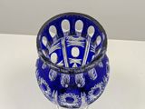 a blue glass vase with spoons in it on a table