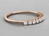 a rose gold ring with five diamonds on a reflective surface