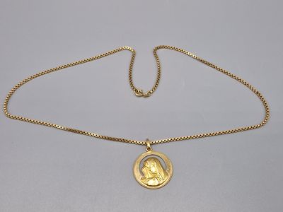 un collier en or avec une pièce de monnaie sur une chaîne