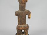 an old wooden statue of a man sitting on top of a table