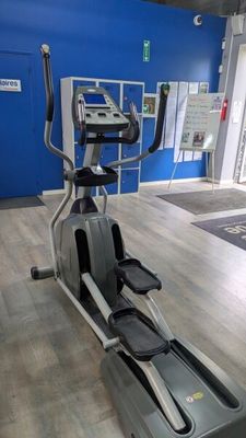 an image of a gym room with a tread machine and a blue wall