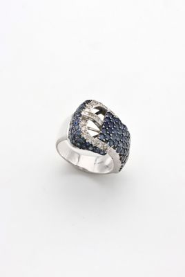 un gros plan d'une bague en argent sertie de diamants bleus et blancs